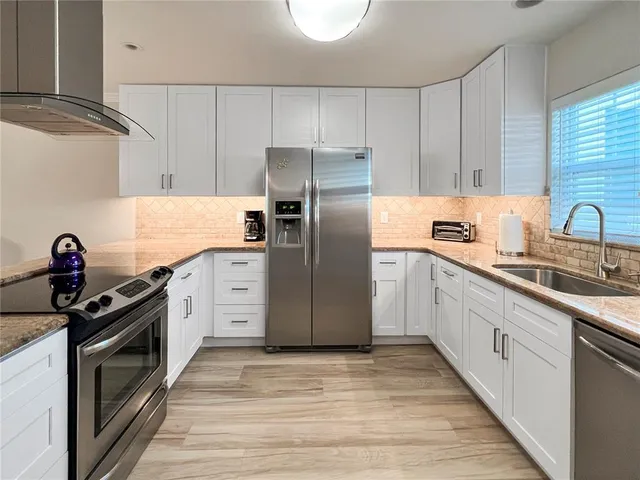 a kitchen with stainless steel appliances granite countertop a sink stove and refrigerator