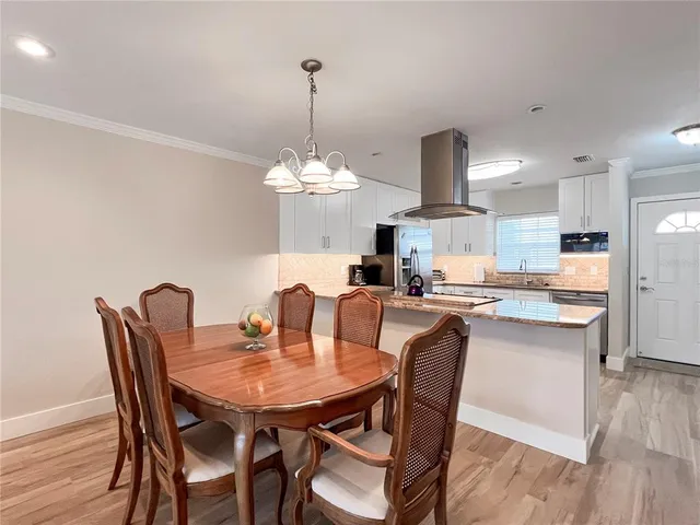 a view of a dining room and a kitchen with a table chairs