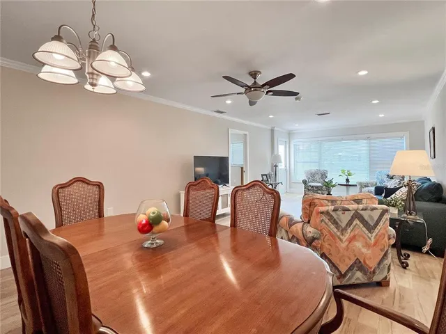 a view of a dining room with furniture a chandelier and wooden floor