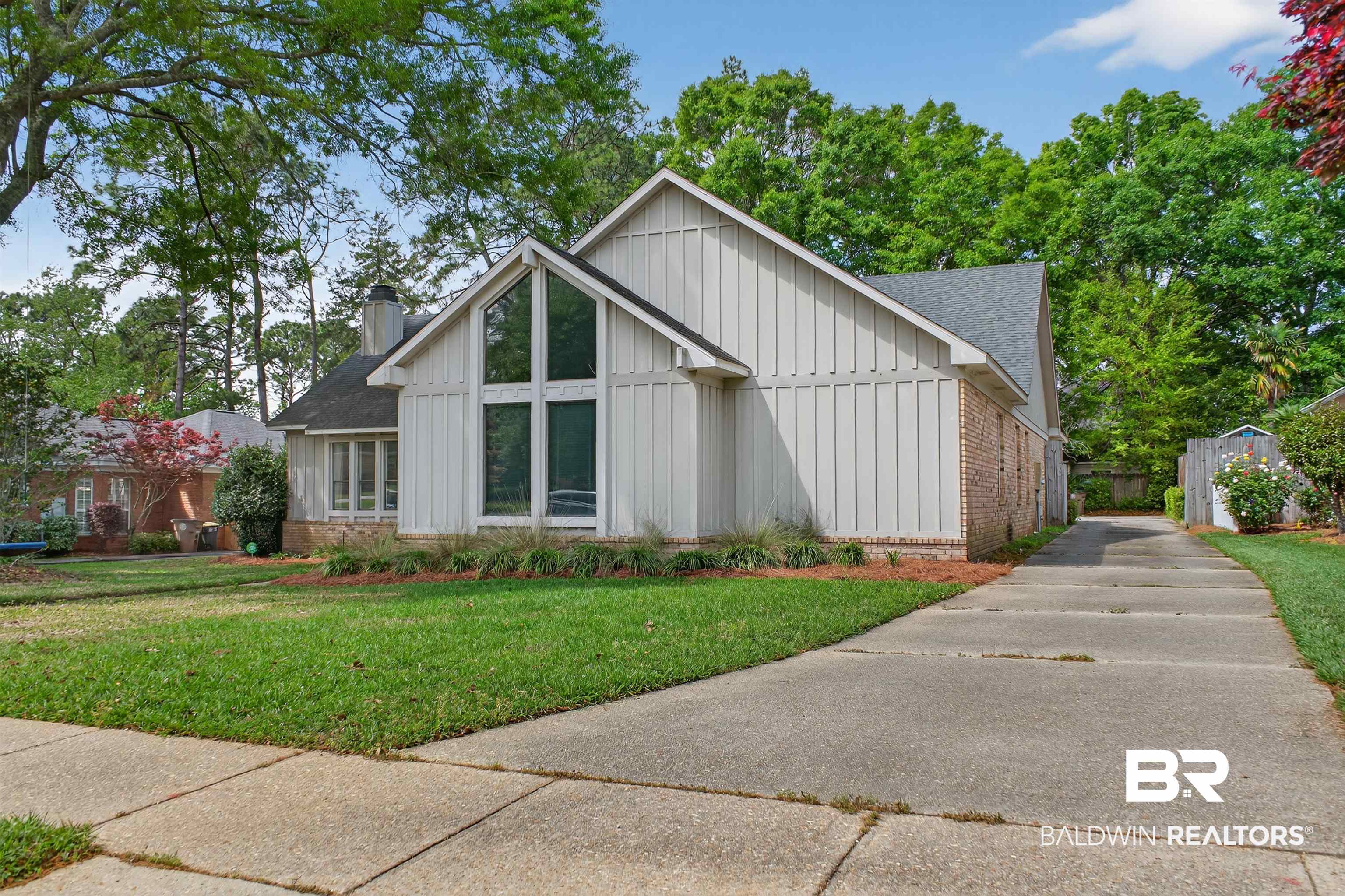 1250 Savannah Drive Mobile, AL 36609 - Photo 4 of 35 View of front of house featuring board and batten siding, brick siding, a front lawn, and roof with shingles