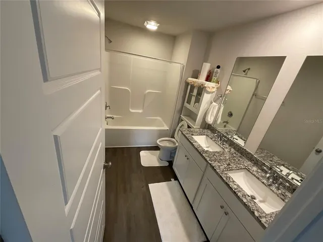 a bathroom with a granite countertop sink toilet and shower