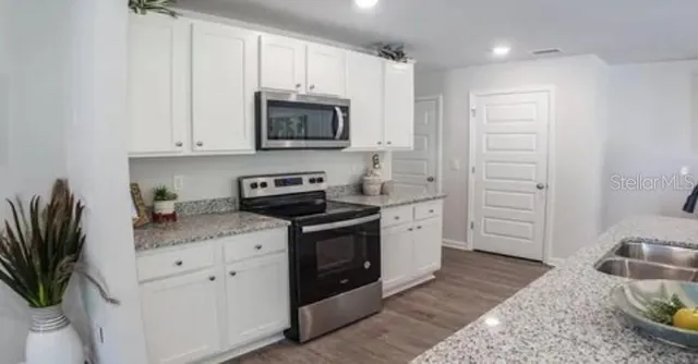 a kitchen with appliances a sink and cabinets