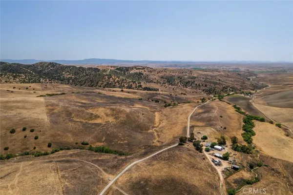 an aerial view of house with yard and mountain view in back