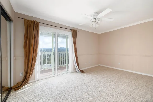 an empty room with a ceiling fan and window