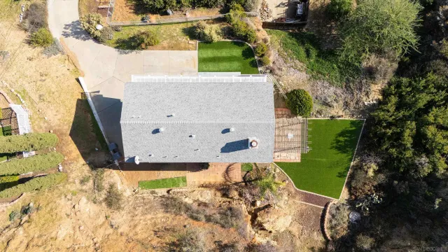 an aerial view of house with yard and mountain view in back