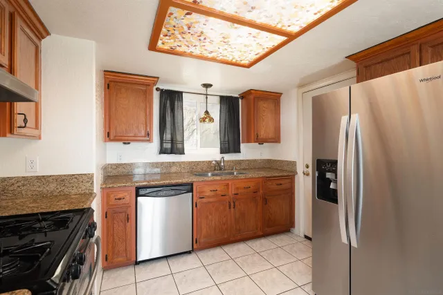 a kitchen with stainless steel appliances granite countertop a refrigerator and a sink