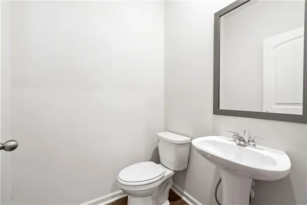 a bathroom with a sink a toilet and mirror