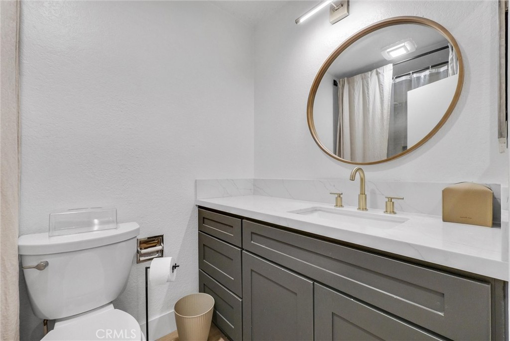 24461 Willow Run Road Moreno Valley, CA 92557 - Photo 17 of 24 a bathroom with a toilet a sink and a mirror