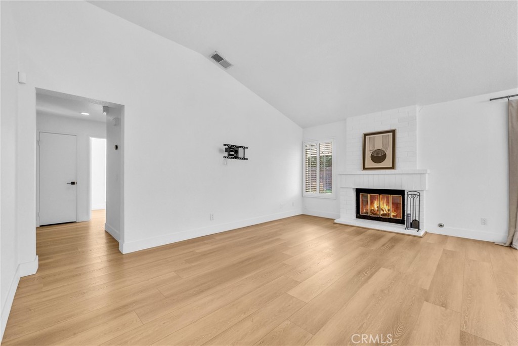 24461 Willow Run Road Moreno Valley, CA 92557 - Photo 3 of 24 a view of an empty room with wooden floor and a fireplace