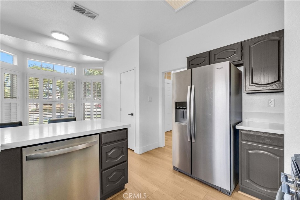 24461 Willow Run Road Moreno Valley, CA 92557 - Photo 7 of 24 a kitchen with granite countertop a refrigerator and a sink