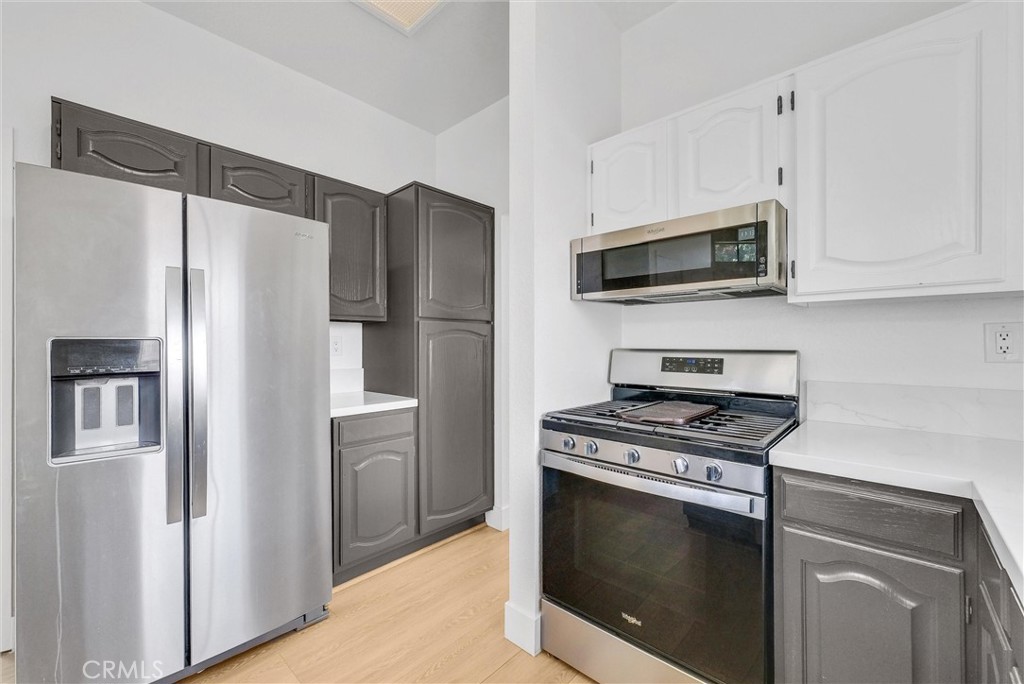 24461 Willow Run Road Moreno Valley, CA 92557 - Photo 8 of 24 a kitchen with cabinets stainless steel appliances and wooden floor