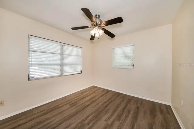 a view of wooden floor and a chandelier fan in a room