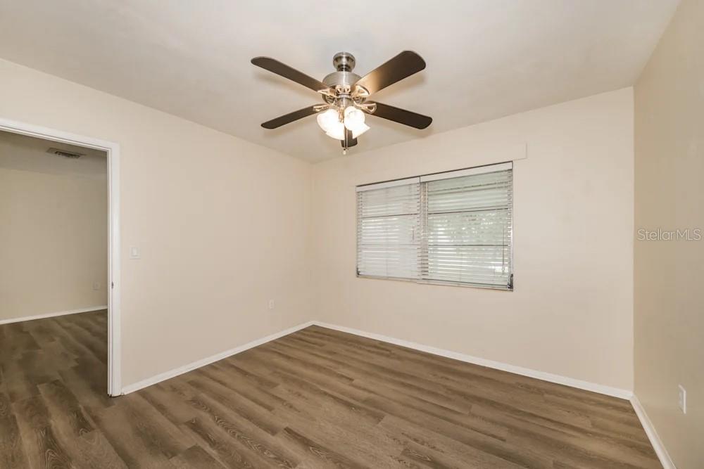 1109 Myrtle Avenue Venice, FL 34285 - Photo 5 of 15 a view of an empty room with wooden floor and a ceiling fan