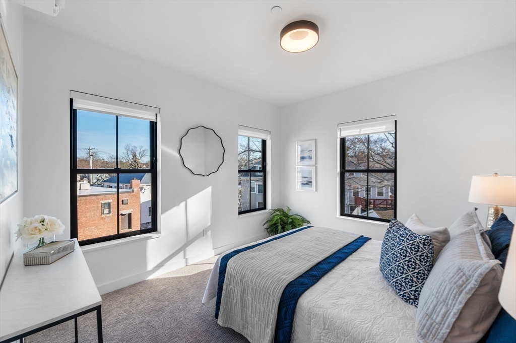 11 Boynton Street, Unit 204 Swampscott, MA 01907 - Photo 23 of 42 a bedroom with a large bed and a chandelier