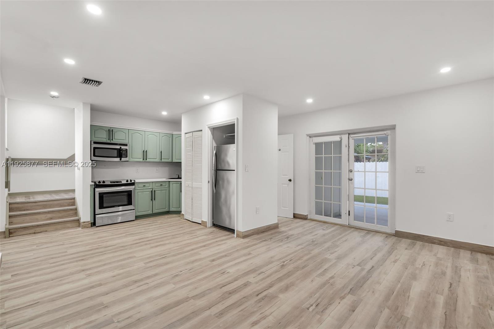 a view of kitchen with stainless steel appliances kitchen island wooden floor and window