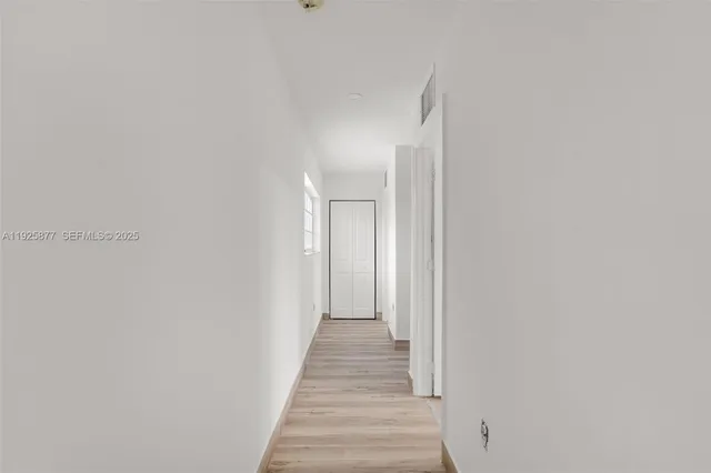 a view of a hallway with wooden floor