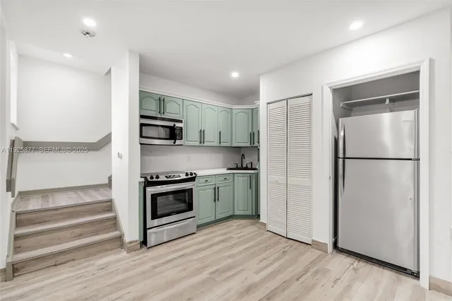 a kitchen with stainless steel appliances granite countertop a refrigerator and a stove top oven