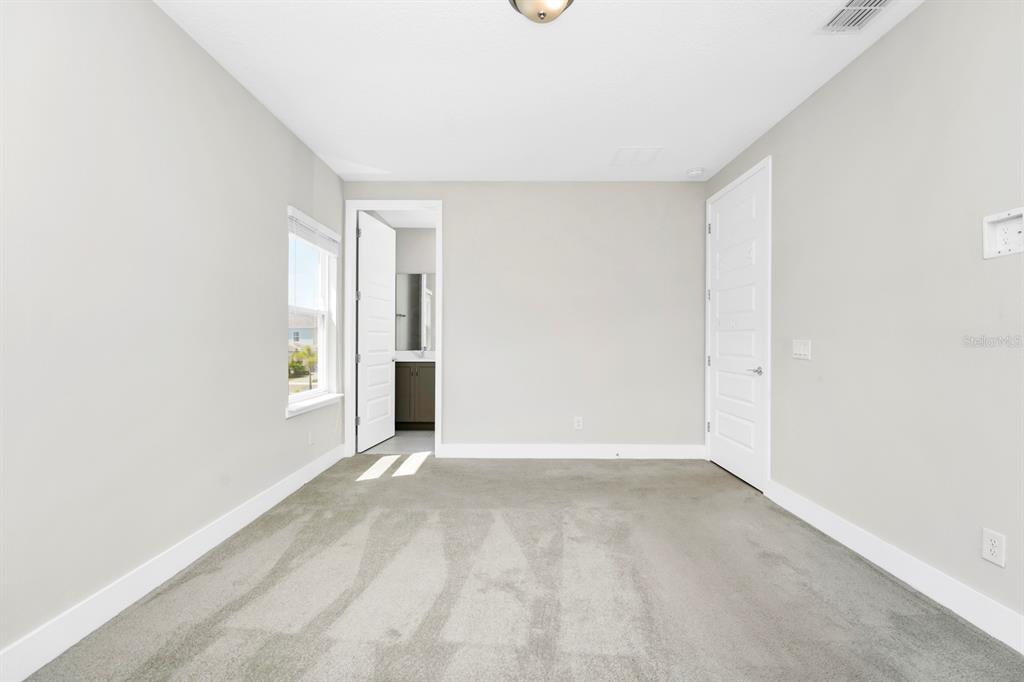 743 Driving Range Court Reunion, FL 34747 - Photo 11 of 38 a view of an empty room with wooden floor and a window