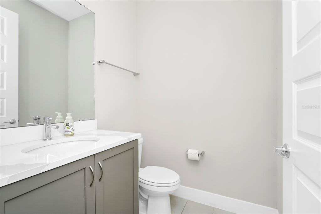 743 Driving Range Court Reunion, FL 34747 - Photo 18 of 38 a bathroom with a sink a toilet and mirror