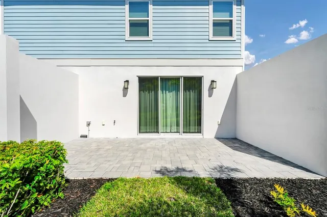 a front view of a house with a yard and potted plants