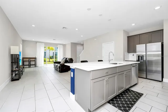 a kitchen with a sink a refrigerator and cabinets