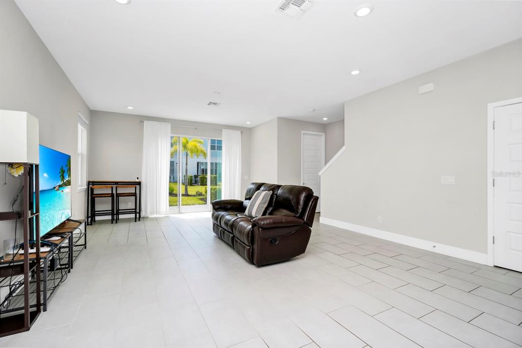 743 Driving Range Court Reunion, FL 34747 - Photo 6 of 38 a living room with furniture and a flat screen tv