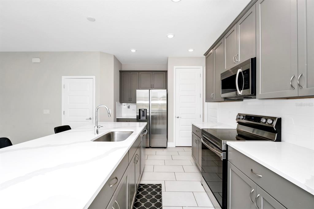 743 Driving Range Court Reunion, FL 34747 - Photo 7 of 38 a kitchen with a sink stove and microwave