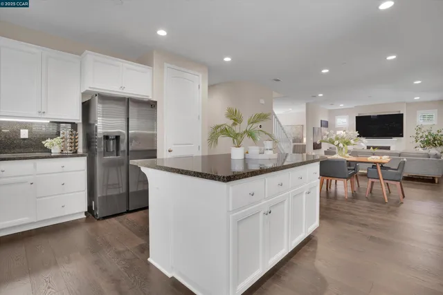 a kitchen with stainless steel appliances kitchen island granite countertop a table and chairs in it
