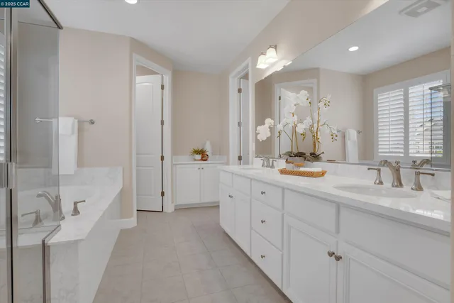 a spacious bathroom with double sink and a large mirror