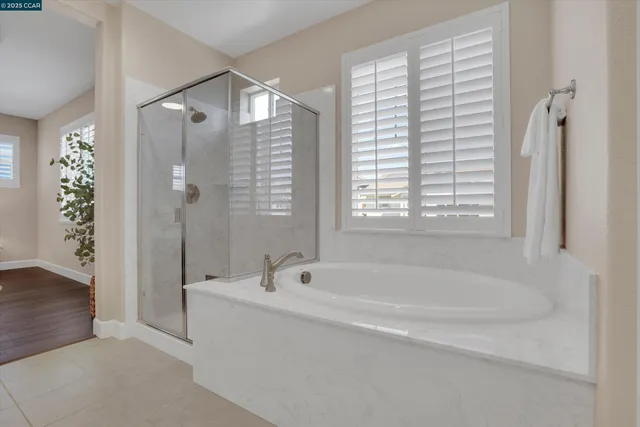 a white bath tub sitting next to a shower