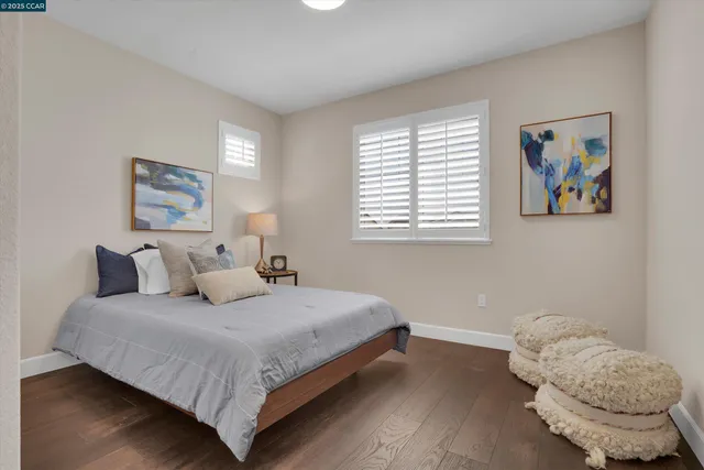 a bedroom with a bed and a painting on the wall