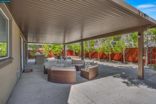 a patio with patio a table and chairs and potted plants