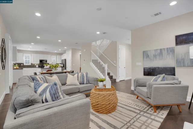 a living room with furniture and a view of kitchen