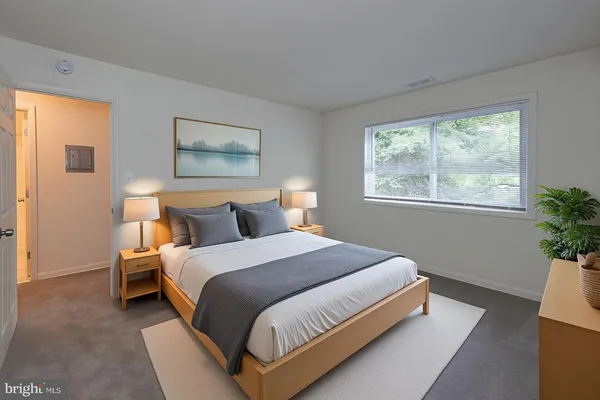a bedroom with a bed lamp and window