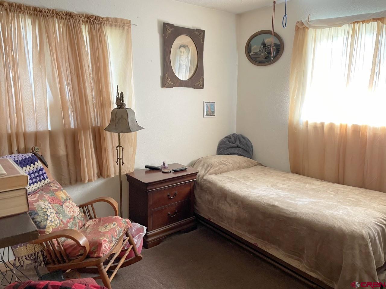1201 Frontier Road Delta, CO 81416 - Photo 11 of 21 a bedroom with a bed and a chandelier