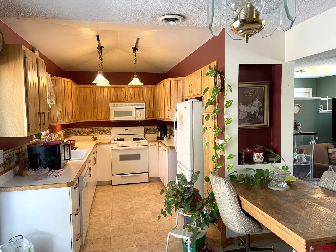 1201 Frontier Road Delta, CO 81416 - Photo 5 of 21 a kitchen with a stove a refrigerator and a dining table