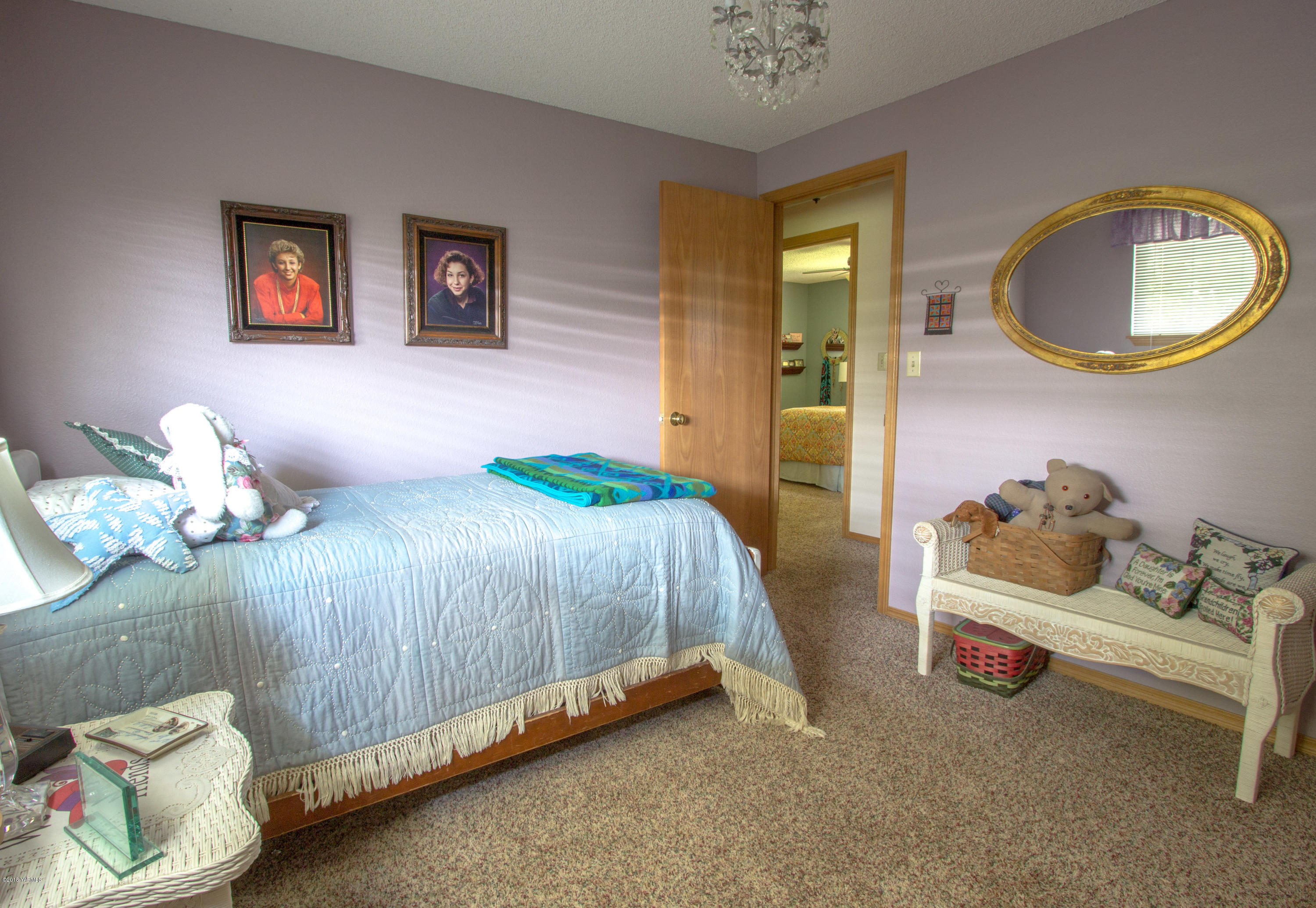 3210 Harrah Road Harrah, WA 98933 - Photo 24 of 33 a bedroom with a bed and a chandelier