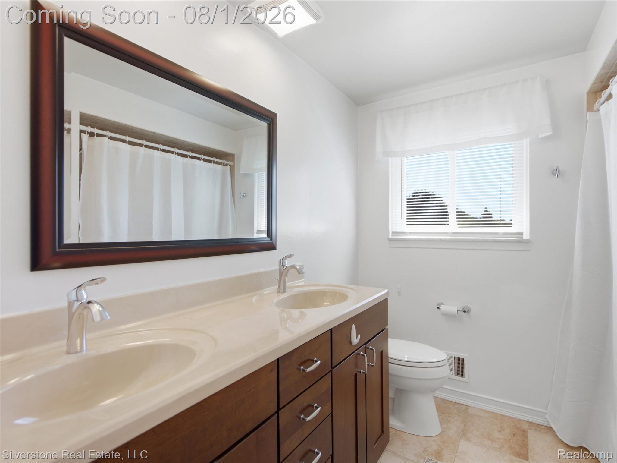 2135 Wayward Drive Rochester, MI 48309 - Photo 33 of 55 Bathroom featuring a double vanity with integrated sinks, chrome fixtures, and a framed mirror