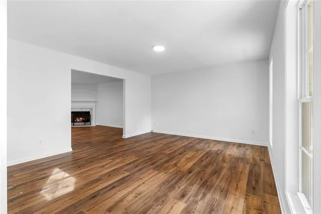 a view of an empty room with a fireplace and a window