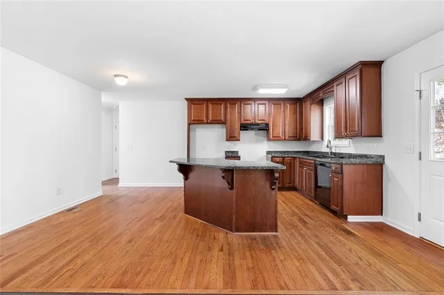 a kitchen with stainless steel appliances granite countertop a stove sink and cabinets