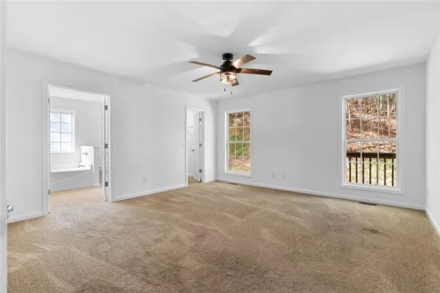 an empty room with closet and windows