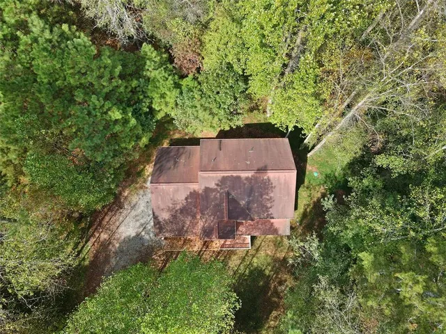 an aerial view of a house with a yard and large trees