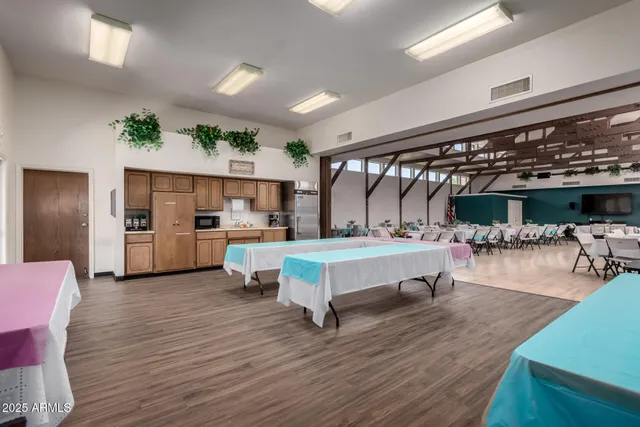 a living room with stainless steel appliances furniture and a kitchen view