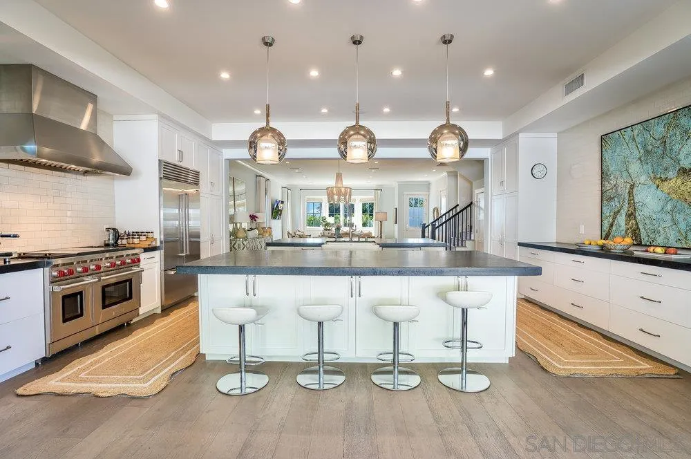 5769 Waverly Avenue La Jolla, CA 92037 - Photo 11 of 30 a kitchen with stainless steel appliances kitchen island granite countertop a stove a sink and a wooden floors