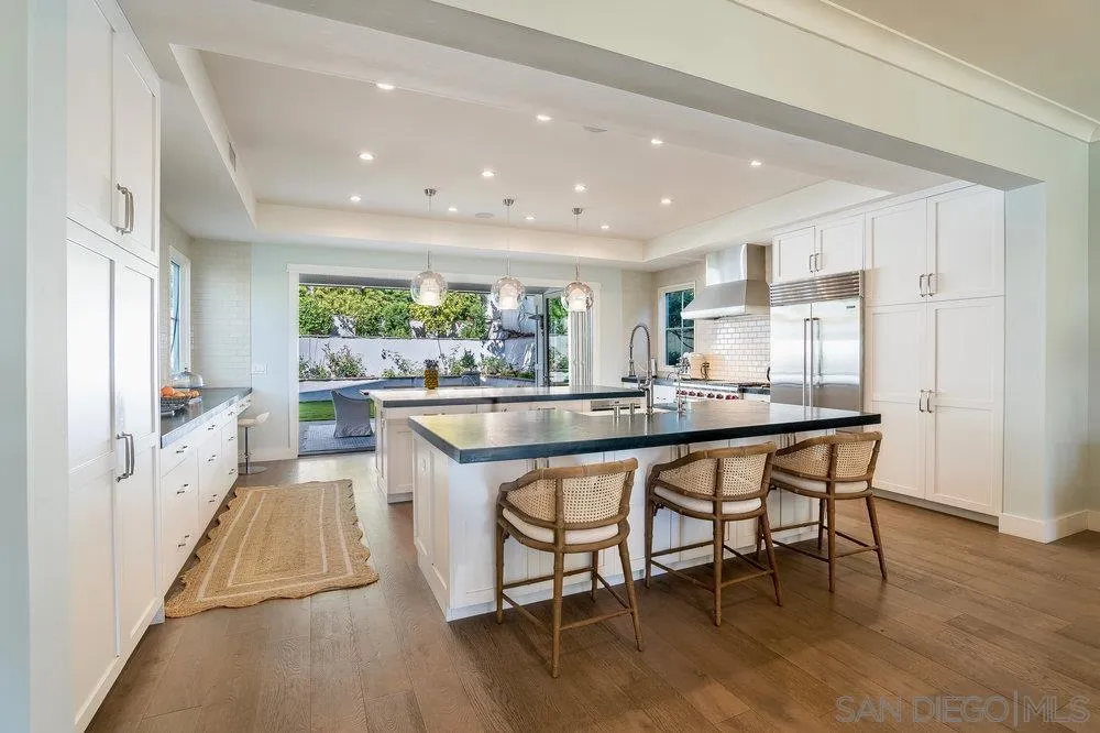 5769 Waverly Avenue La Jolla, CA 92037 - Photo 8 of 30 a dining hall with stainless steel appliances granite countertop a table chairs and a refrigerator