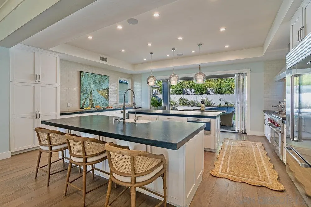 5769 Waverly Avenue La Jolla, CA 92037 - Photo 9 of 30 a kitchen with a table chairs sink and cabinets