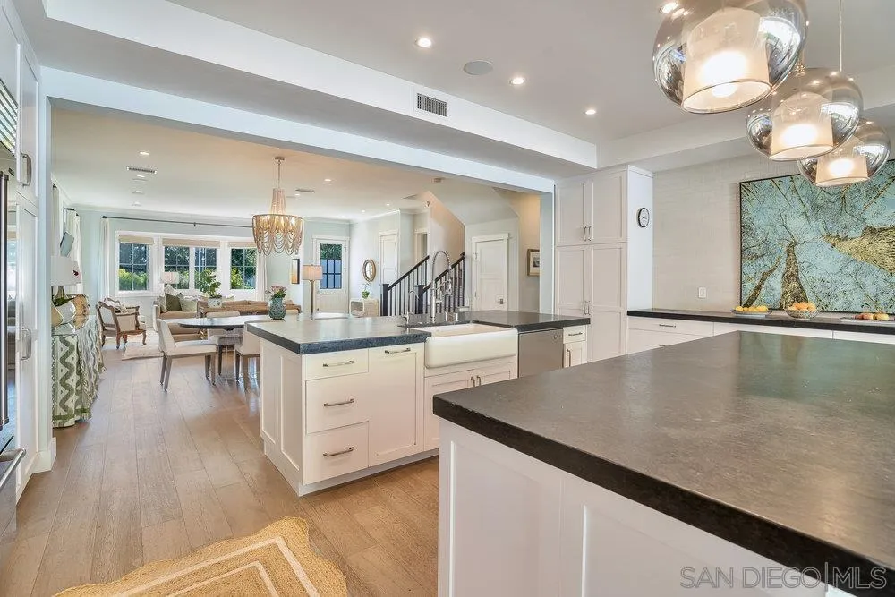 5769 Waverly Avenue La Jolla, CA 92037 - Photo 10 of 30 an open kitchen with white cabinets and chandelier