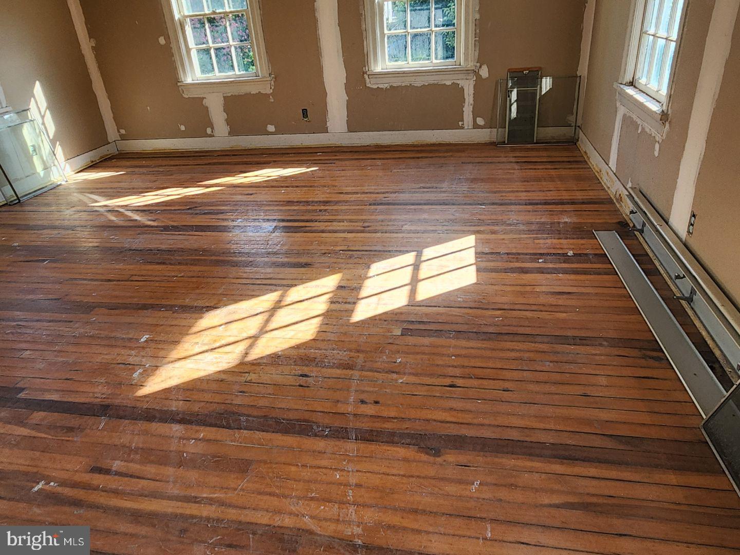 91 West Broadway Salem, NJ 08079 - Photo 11 of 20 a view of an empty room with wooden floor and a window