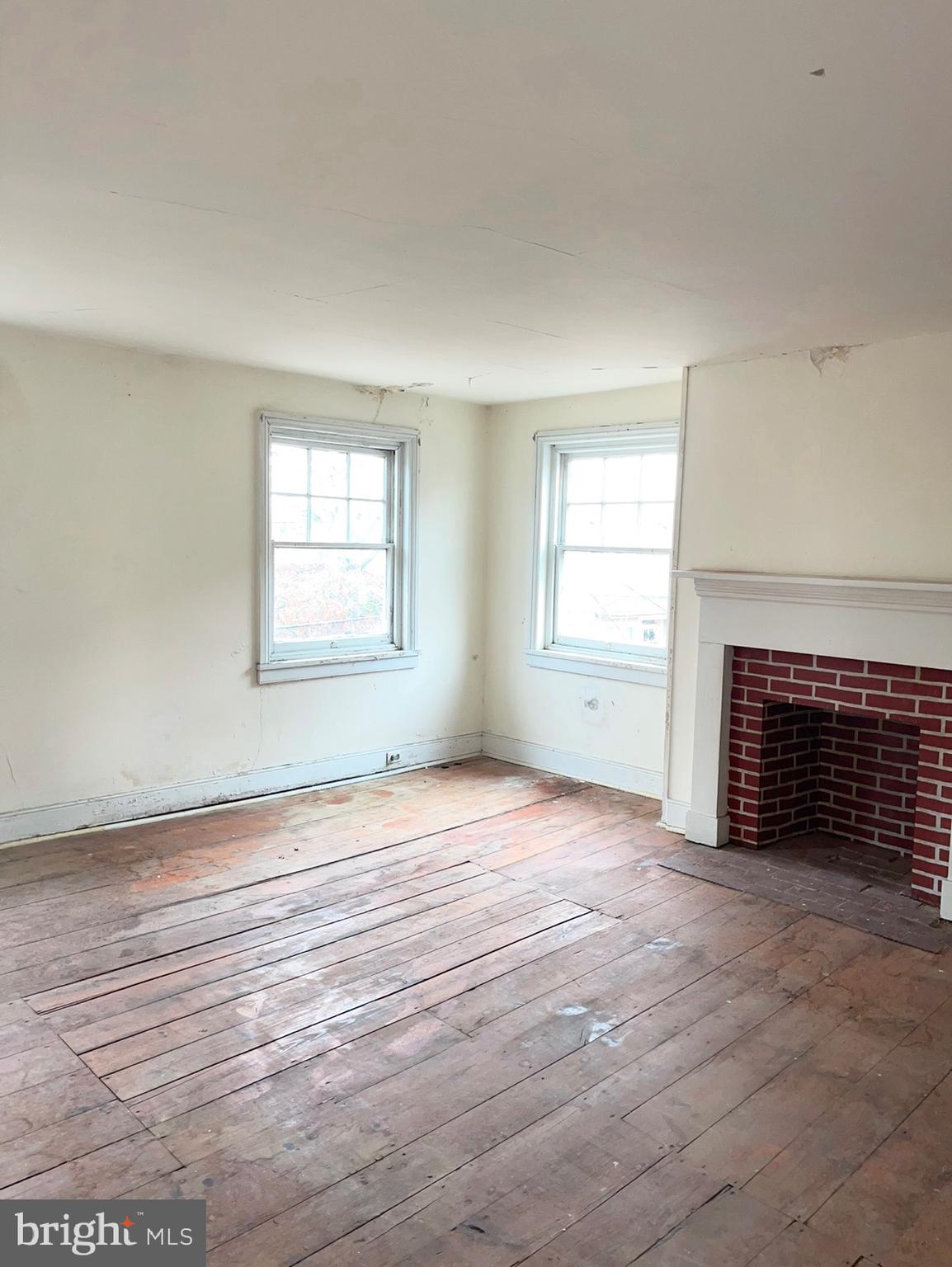 91 West Broadway Salem, NJ 08079 - Photo 17 of 20 an empty room with windows fireplace and wooden floor