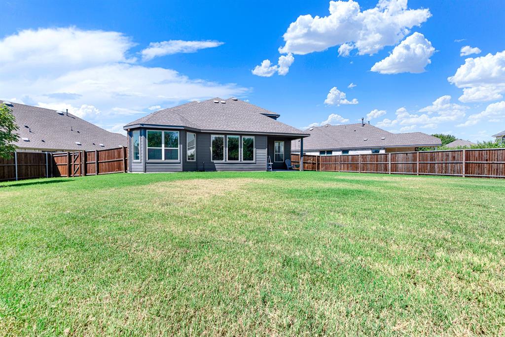 7640 Rhyner Way Fort Worth, TX 76137 - Photo 27 of 40 Expansive backyard featuring a manicured lawn with mature landscaping and wood-finish fencing